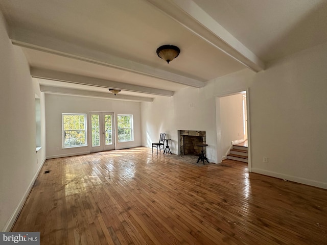 unfurnished living room featuring beam ceiling and wood-type flooring