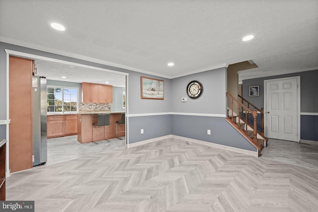 interior space featuring a kitchen bar, ornamental molding, stainless steel refrigerator, and light parquet flooring