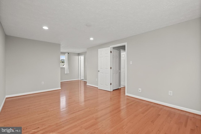 unfurnished room with light hardwood / wood-style floors and a textured ceiling