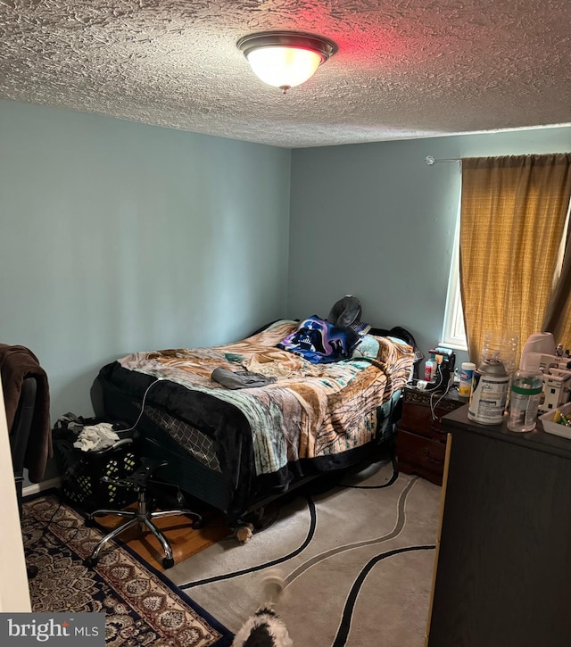 bedroom with carpet and a textured ceiling