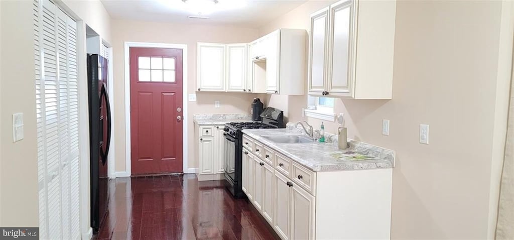 kitchen with plenty of natural light, dark hardwood / wood-style floors, sink, and black range with gas cooktop