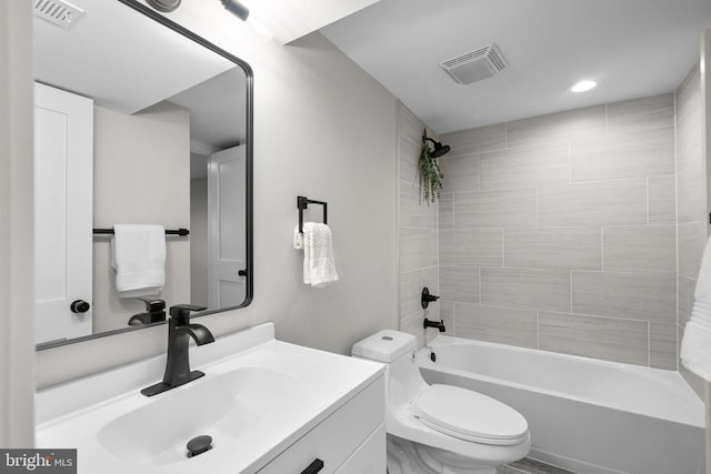 full bathroom with vanity, tiled shower / bath combo, and toilet