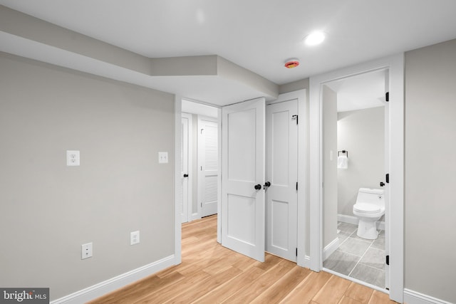 bedroom featuring light hardwood / wood-style flooring and ensuite bath