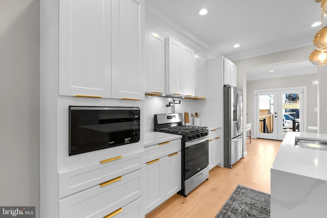 kitchen with white cabinets, appliances with stainless steel finishes, light hardwood / wood-style flooring, ornamental molding, and french doors