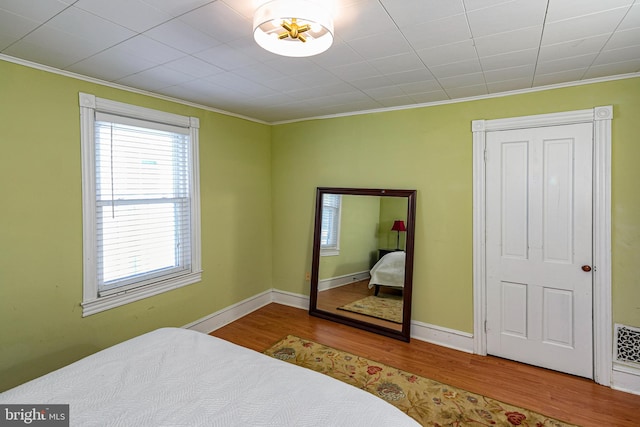 bedroom featuring crown molding and hardwood / wood-style flooring