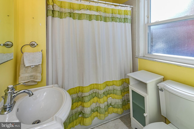 bathroom featuring toilet, tile patterned floors, sink, and a shower with shower curtain