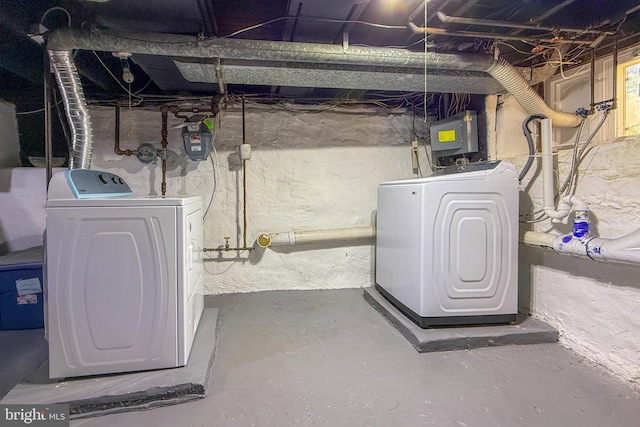 basement with electric panel and washing machine and clothes dryer