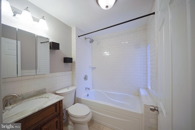 full bathroom with tiled shower / bath combo, toilet, tile walls, and vanity