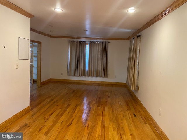 empty room featuring hardwood / wood-style flooring and ornamental molding