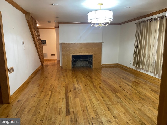 unfurnished living room featuring ornamental molding and light wood-type flooring