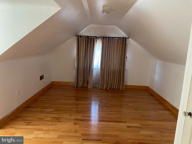 bonus room with light hardwood / wood-style floors and vaulted ceiling