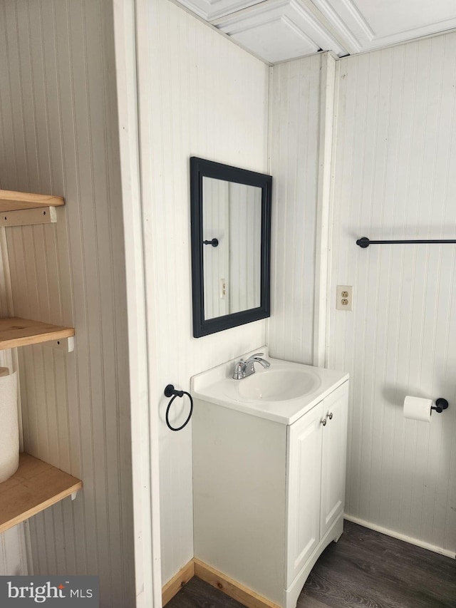 bathroom with vanity, wood walls, and wood-type flooring