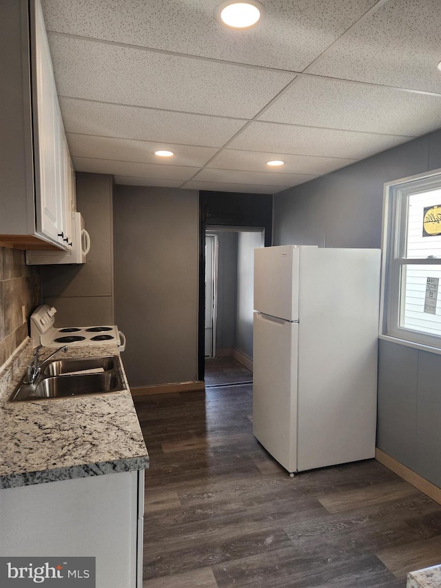 kitchen featuring sink, white cabinetry, a paneled ceiling, white appliances, and dark hardwood / wood-style flooring