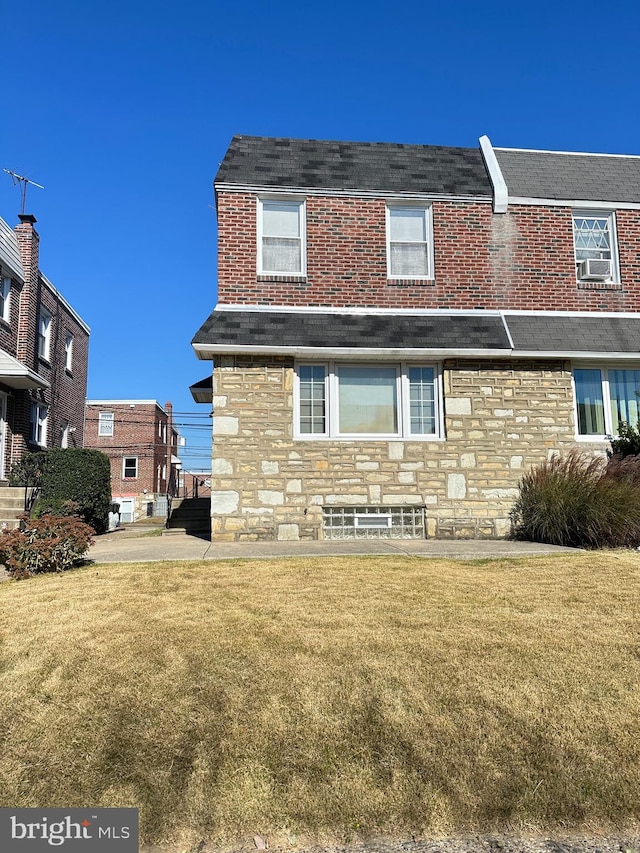 view of front of home featuring cooling unit and a front lawn