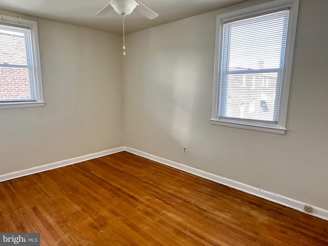 spare room featuring wood-type flooring and a healthy amount of sunlight