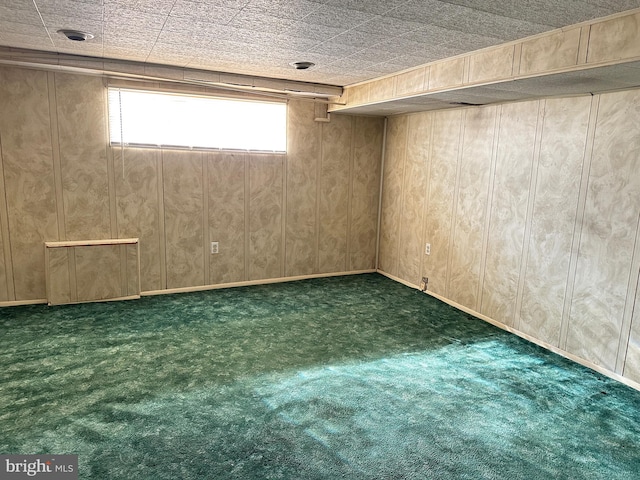 basement featuring wood walls and dark carpet