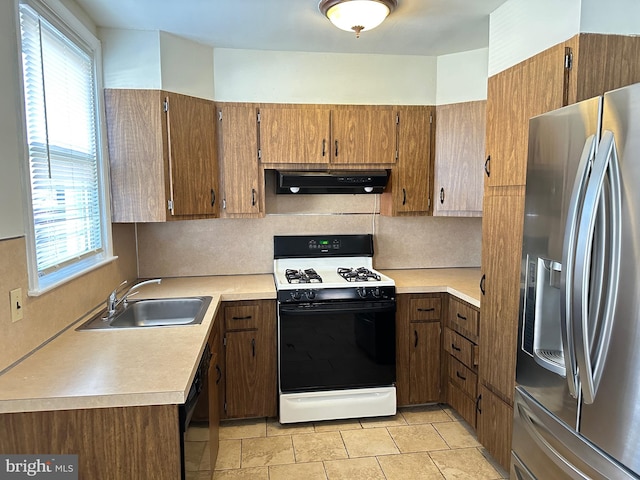 kitchen with exhaust hood, stainless steel refrigerator with ice dispenser, gas range gas stove, sink, and tasteful backsplash