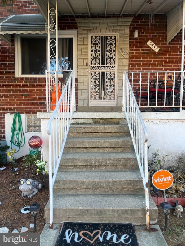 5437 Force Rd, Baltimore, MD 21206 - doorway to property featuring covered porch and brick siding