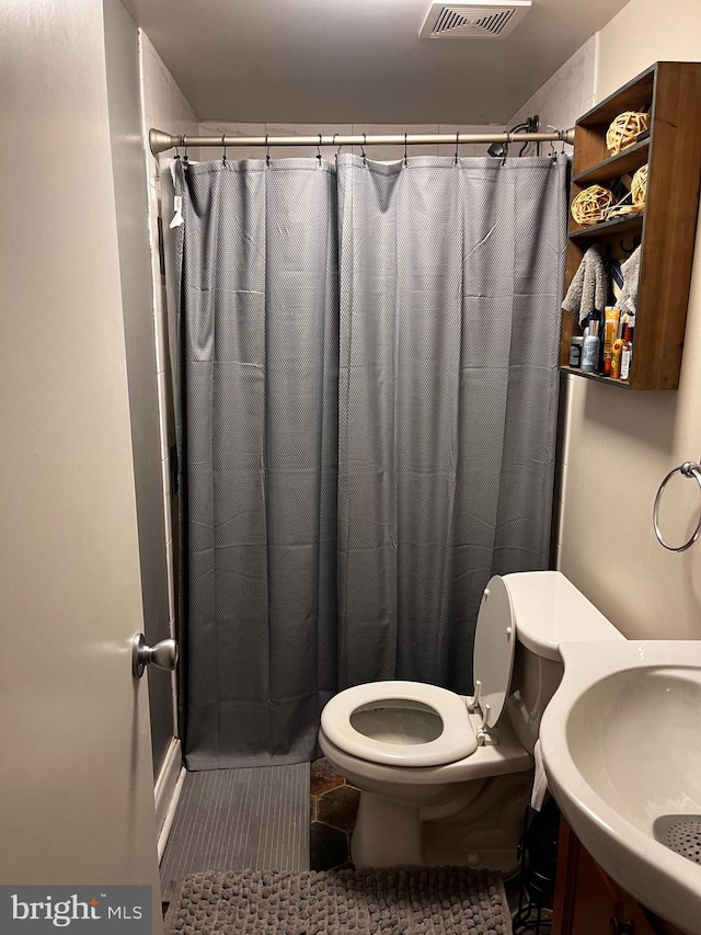 bathroom featuring walk in shower, sink, and toilet