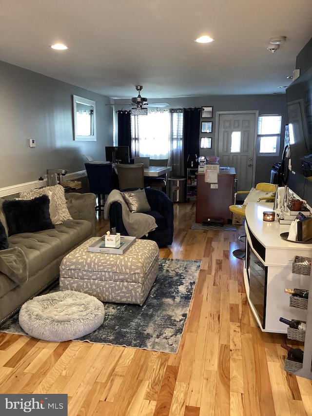 living room featuring ceiling fan, a wealth of natural light, and light hardwood / wood-style flooring