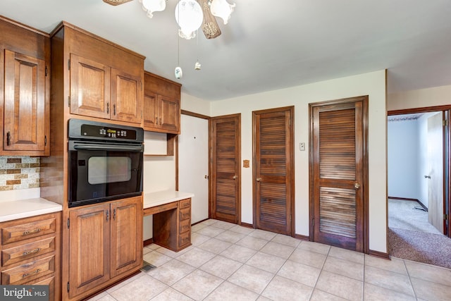 kitchen with oven, light tile patterned floors, and backsplash