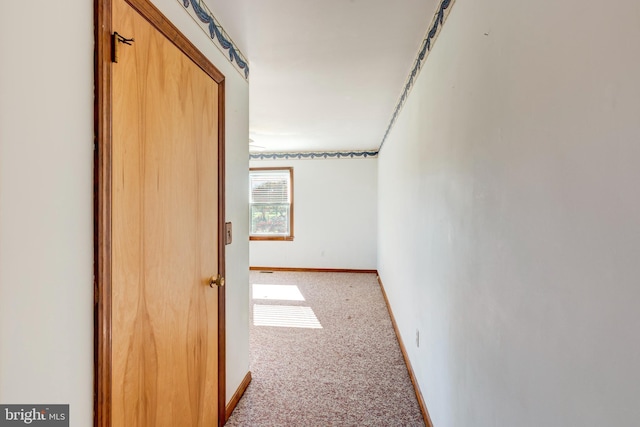 hall featuring light colored carpet