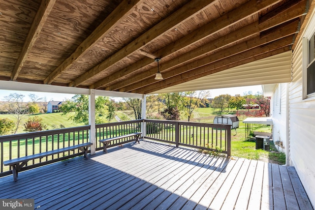 deck featuring a storage unit, a yard, and central air condition unit