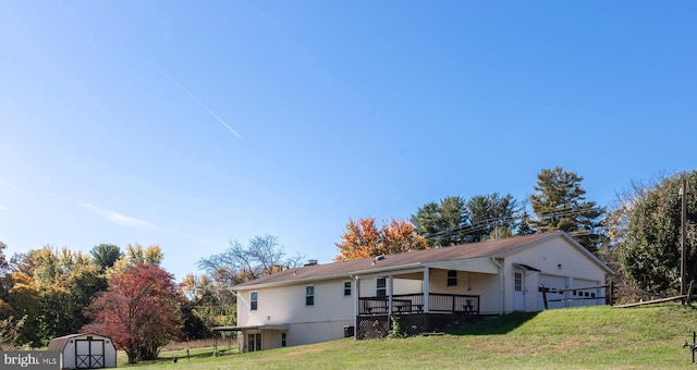 rear view of house with a yard and a shed