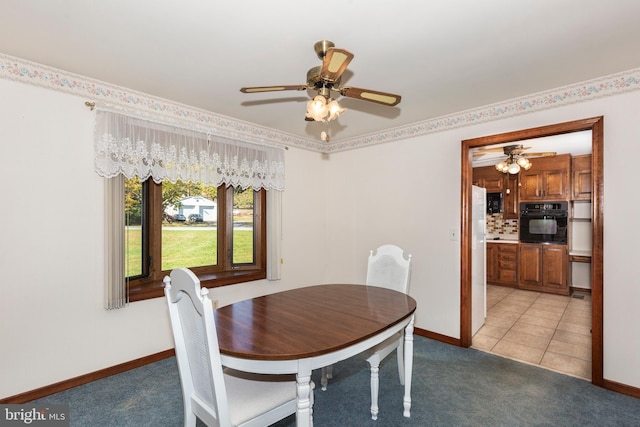 carpeted dining room with ceiling fan