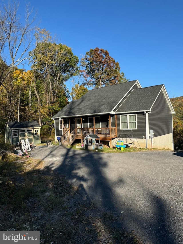 view of front of house with a wooden deck and a storage shed