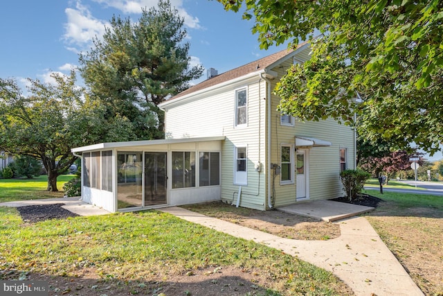 view of front of home featuring a sunroom and a front yard