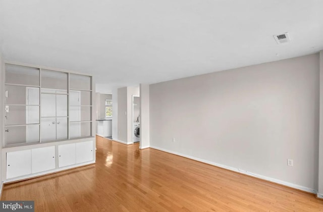 unfurnished living room featuring light hardwood / wood-style floors and washer / dryer