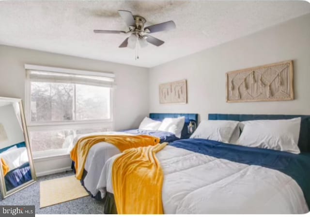 carpeted bedroom with a textured ceiling and ceiling fan