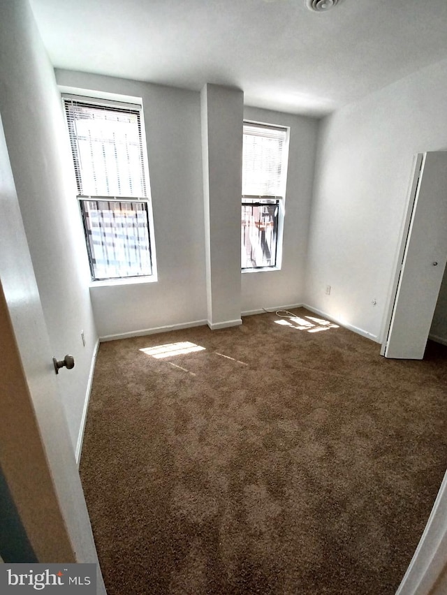 unfurnished bedroom with dark carpet