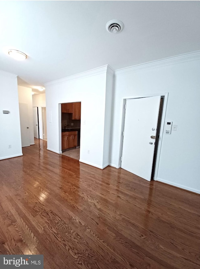 unfurnished living room with ornamental molding and dark hardwood / wood-style floors