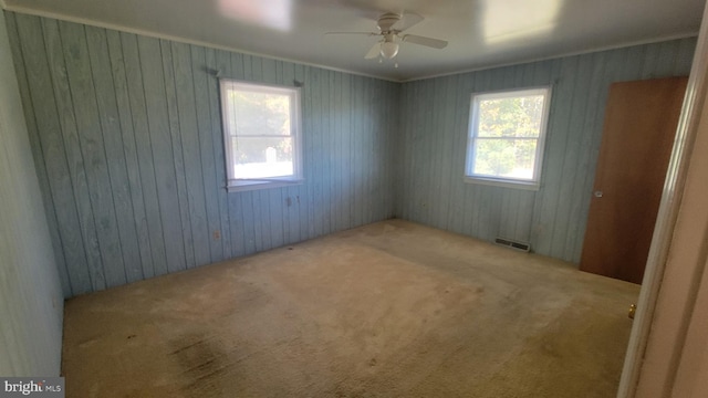 carpeted empty room featuring ceiling fan and crown molding