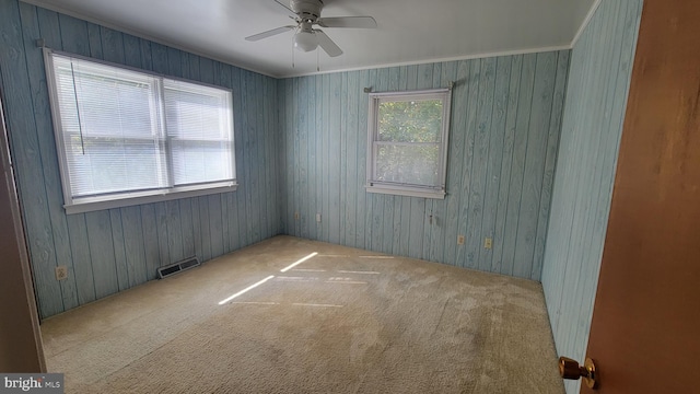 unfurnished room featuring crown molding, light colored carpet, and ceiling fan