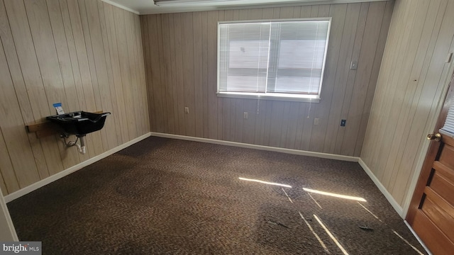 empty room with wooden walls and dark carpet