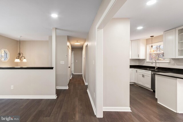 hallway featuring dark hardwood / wood-style flooring, sink, and a notable chandelier