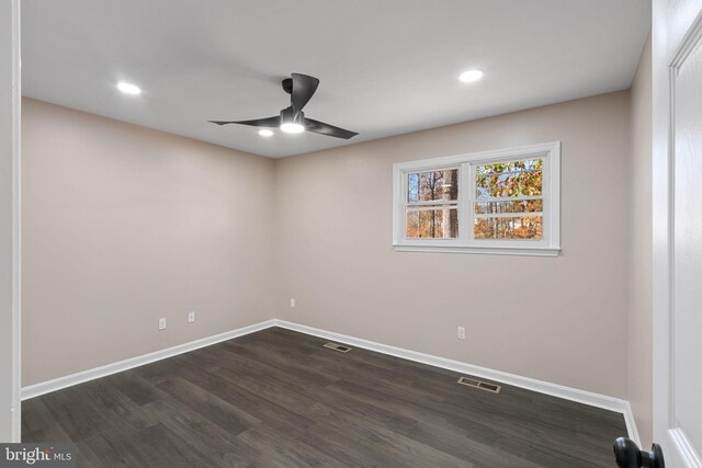 spare room with dark wood-type flooring and ceiling fan