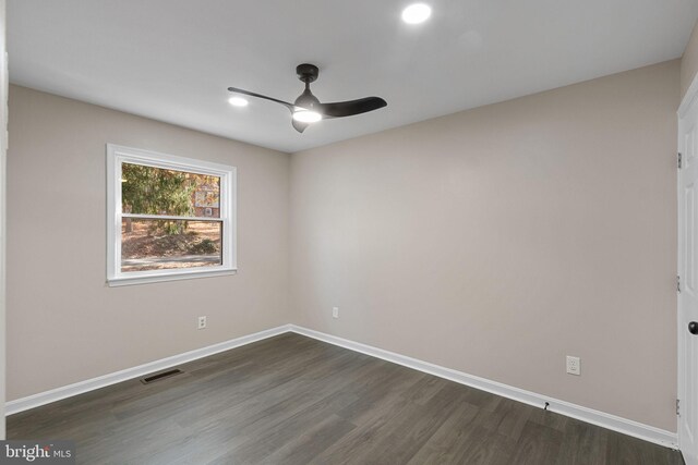 empty room featuring dark hardwood / wood-style flooring and ceiling fan