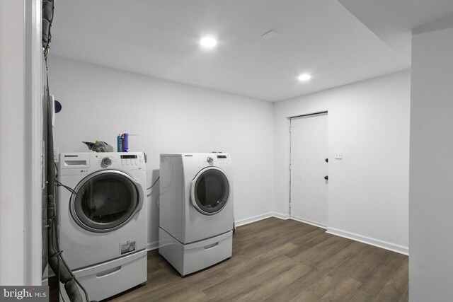 laundry area with washing machine and clothes dryer and dark hardwood / wood-style floors