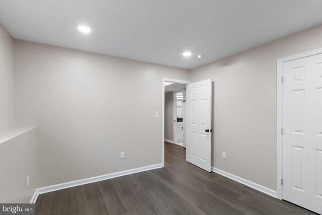 unfurnished room with dark wood-type flooring