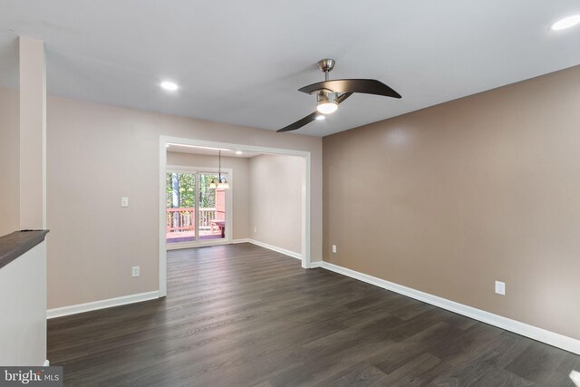 unfurnished living room with dark wood-type flooring and ceiling fan with notable chandelier