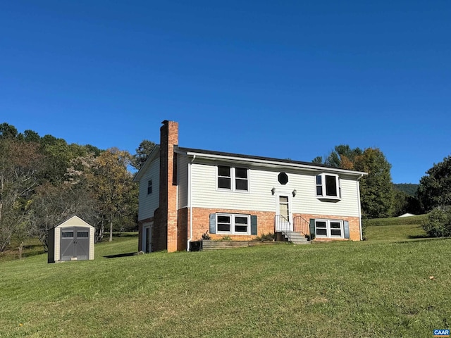 split foyer home featuring a front yard, a shed, and central AC