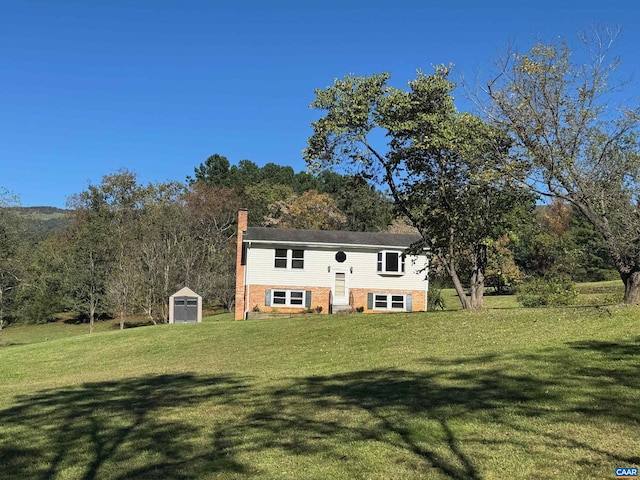 raised ranch with a shed and a front lawn