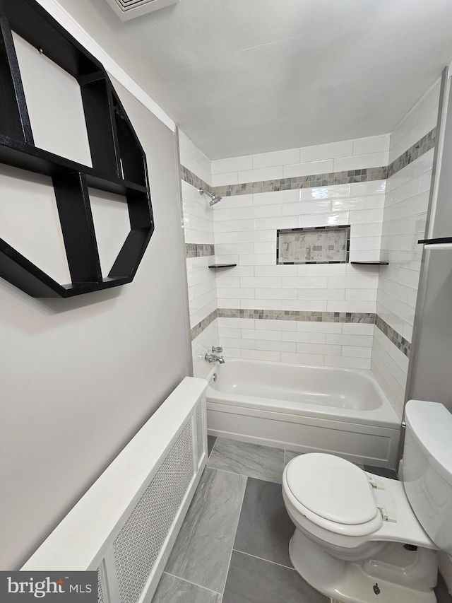 bathroom with tile patterned floors, tiled shower / bath combo, toilet, and radiator