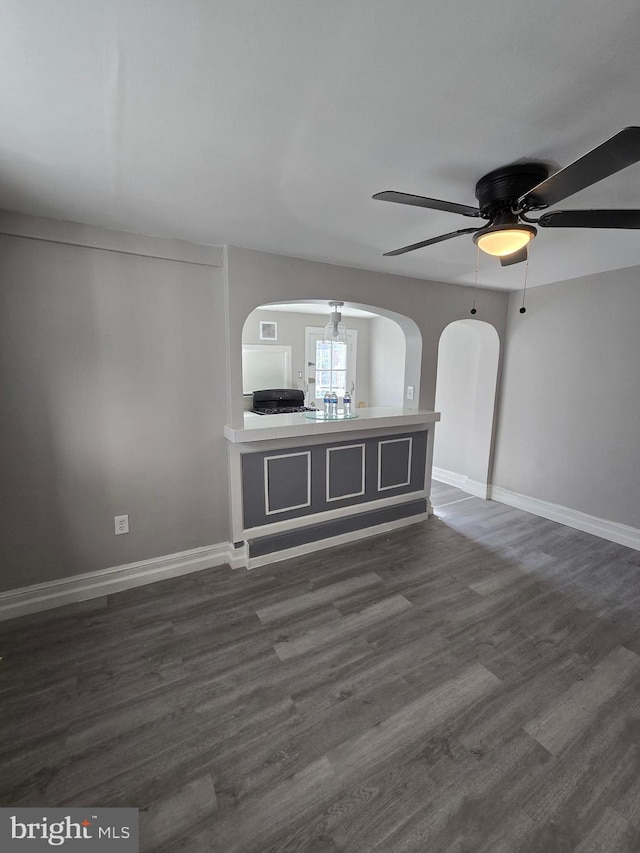 unfurnished living room featuring dark hardwood / wood-style floors and ceiling fan