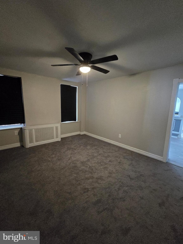 carpeted empty room with radiator heating unit, a textured ceiling, and ceiling fan