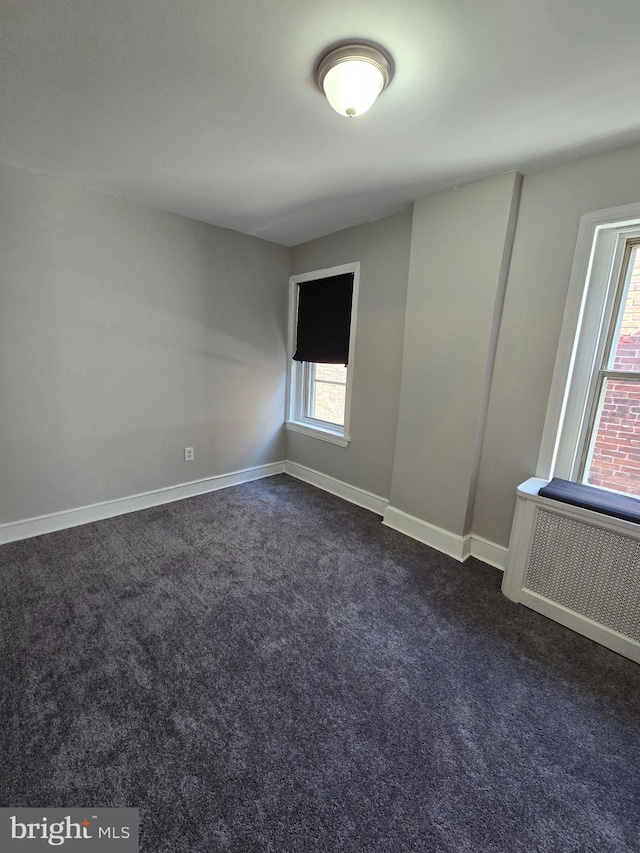 empty room featuring dark colored carpet